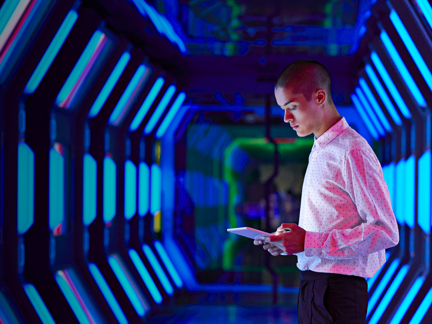Wissen und Inspiration Blog Mann steht in einem blauen Tunnel und schaut auf ein Tablet